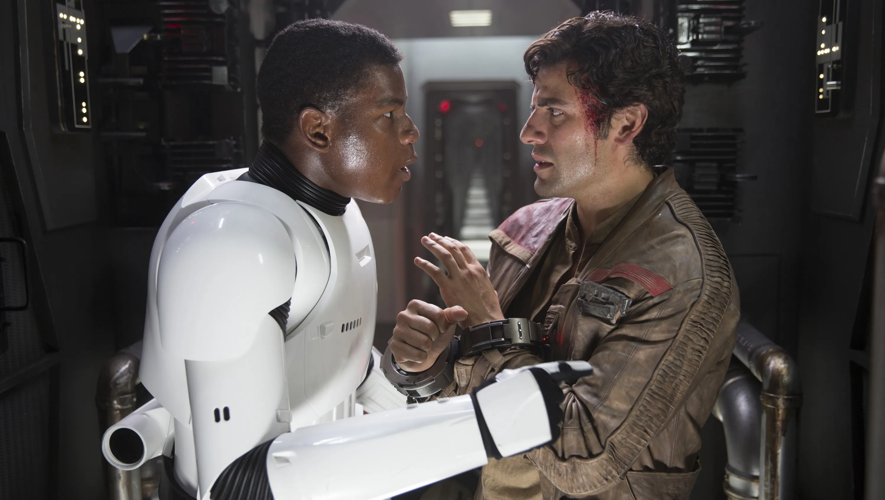 John Boyega as Finn in Stormtrooper armor facing Oscar Isaac as Poe Dameron