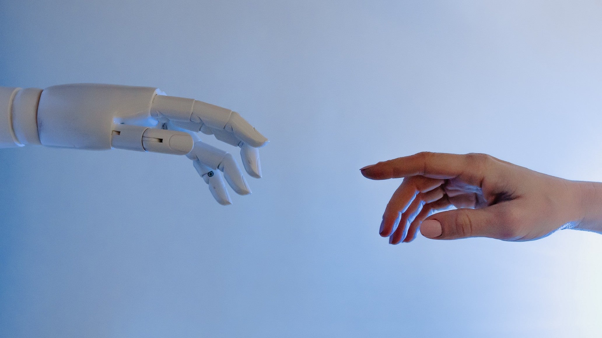 A robot hand and a human hand reach out to each other