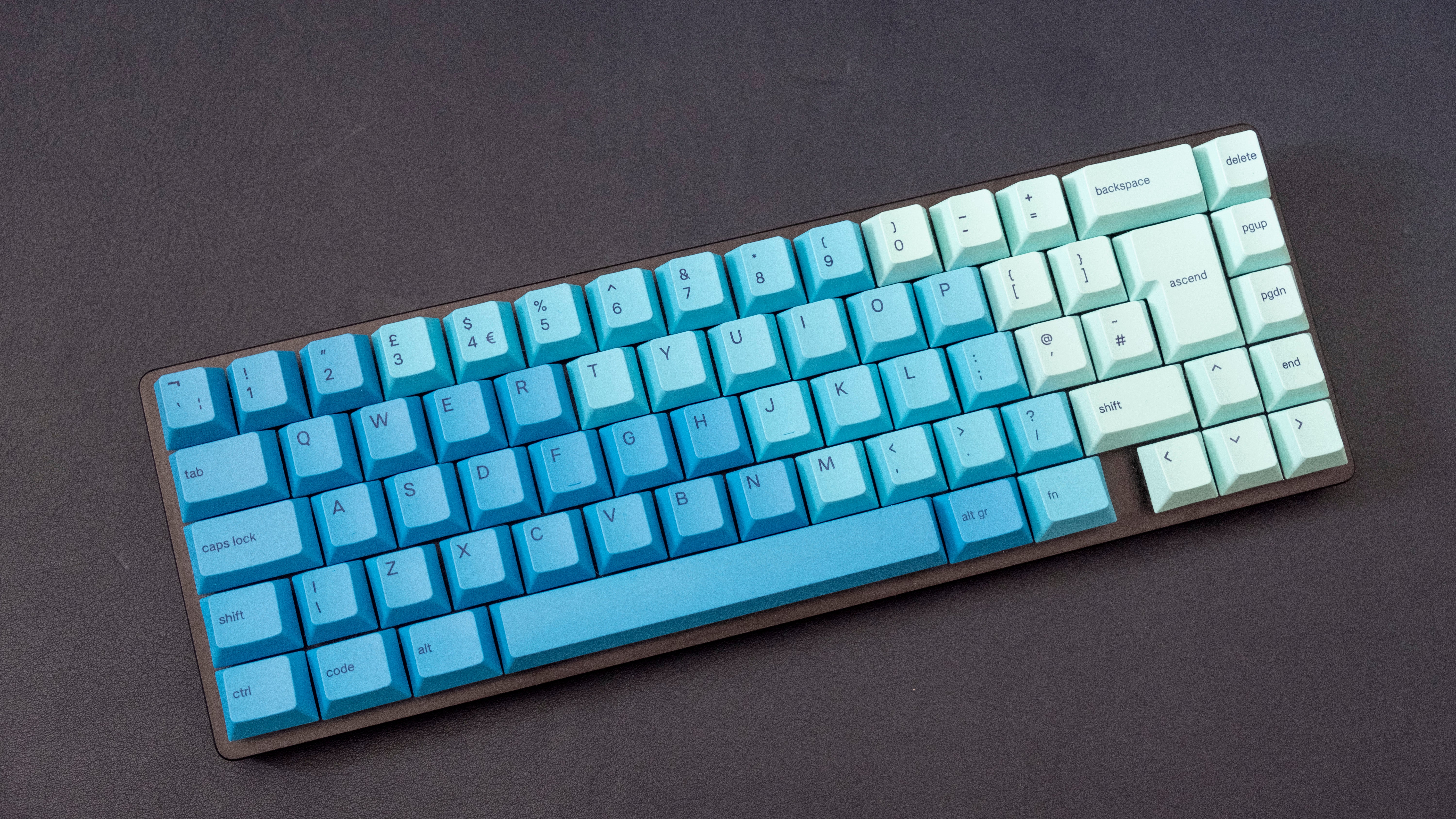 a customised glorious modular keyboard, the GMMK 2, with green and blue keycaps and a compact 65% layout