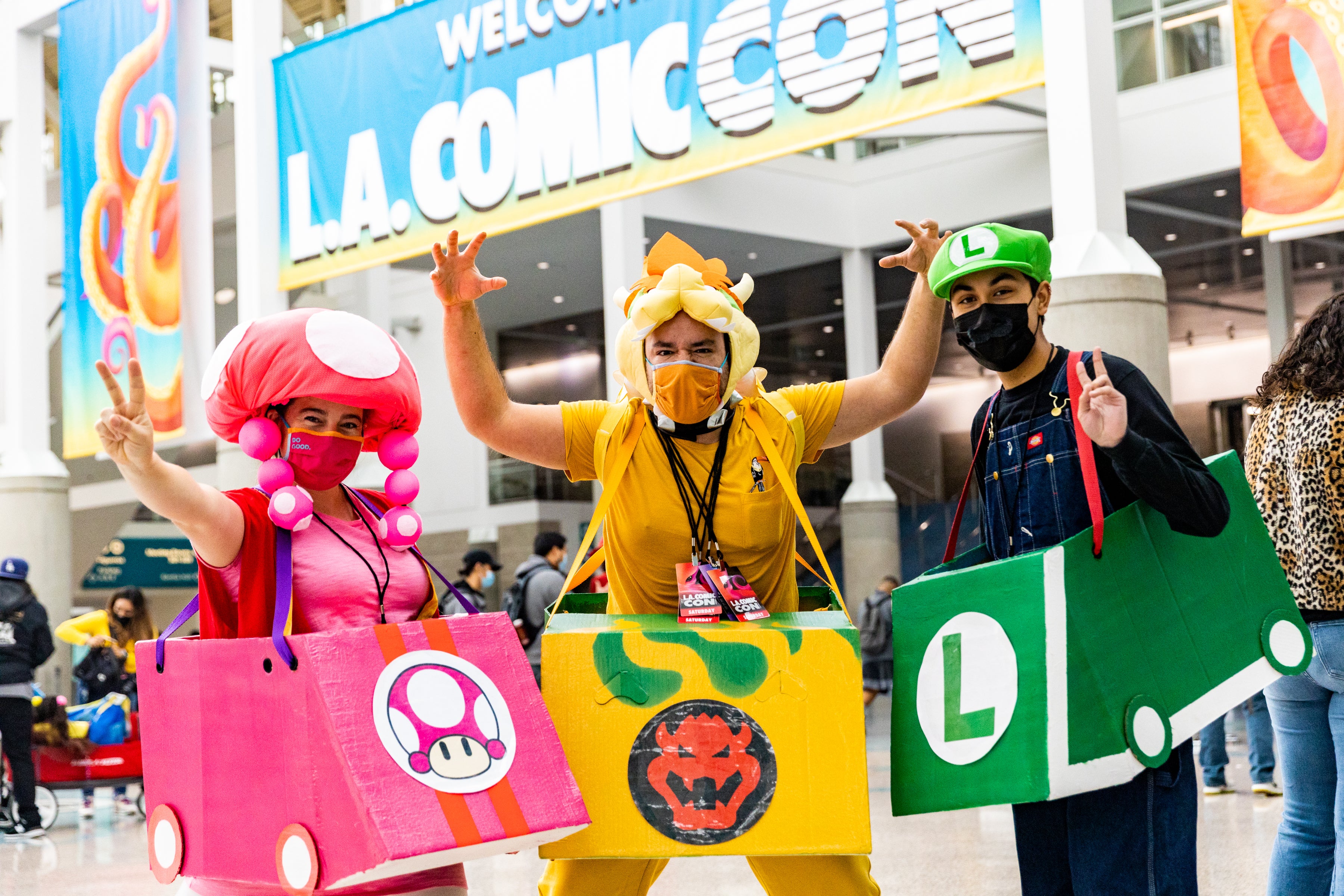 Three cosplayers as MarioKart characters wearing masks
