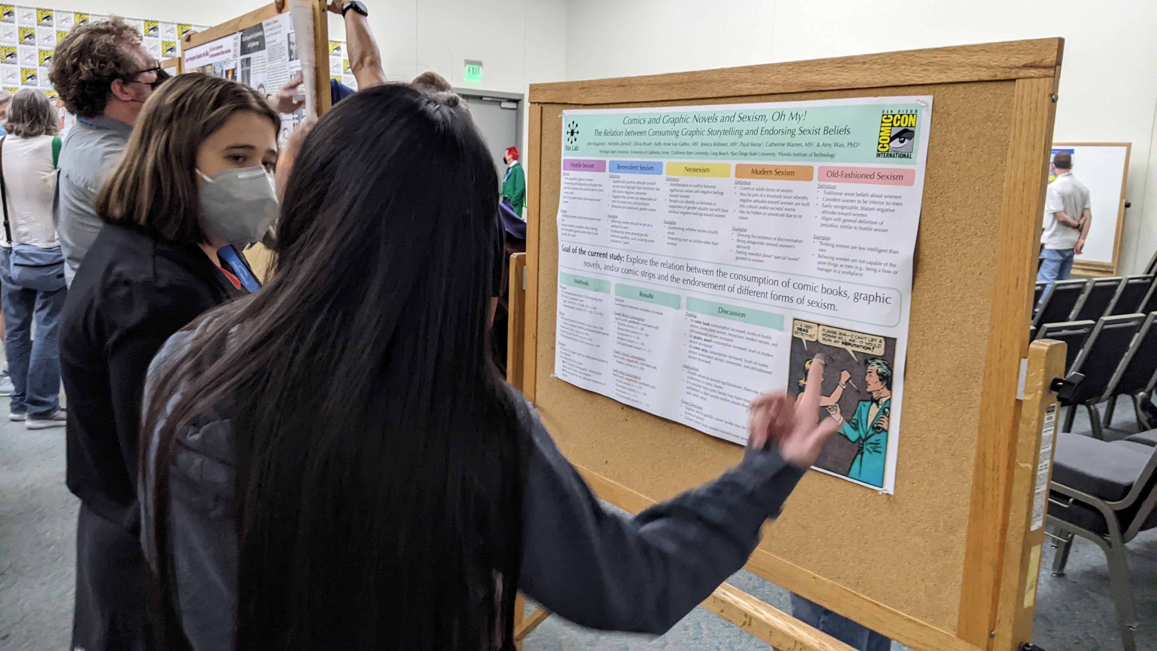 Two people standing in front of an academic poster discussing it