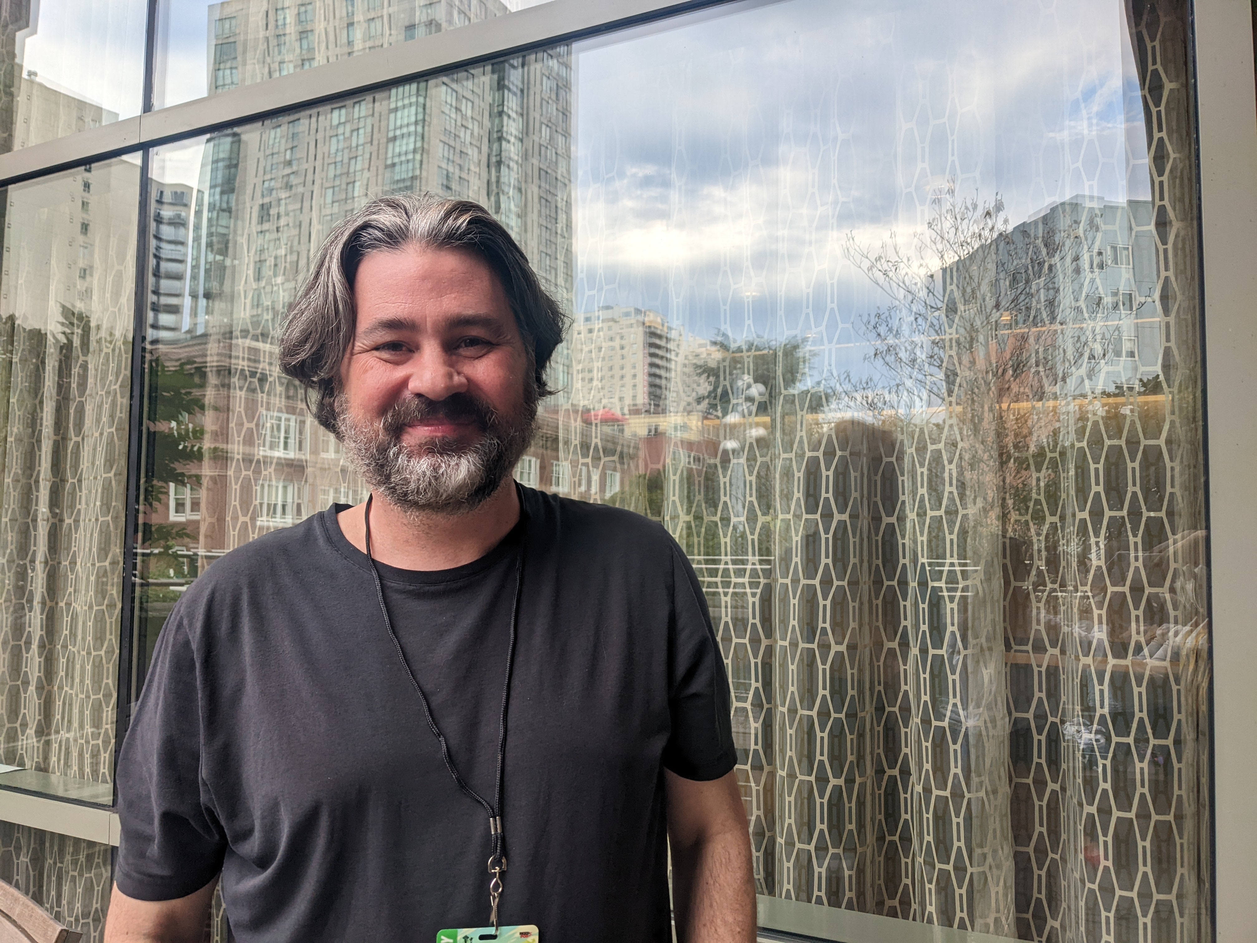 Jonathan Hickman with a background of an exterior of a window and curtain