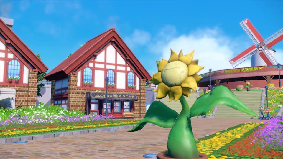 Pokémon Scarlet Violet - a Sunflora statue in front of a town with a windmill