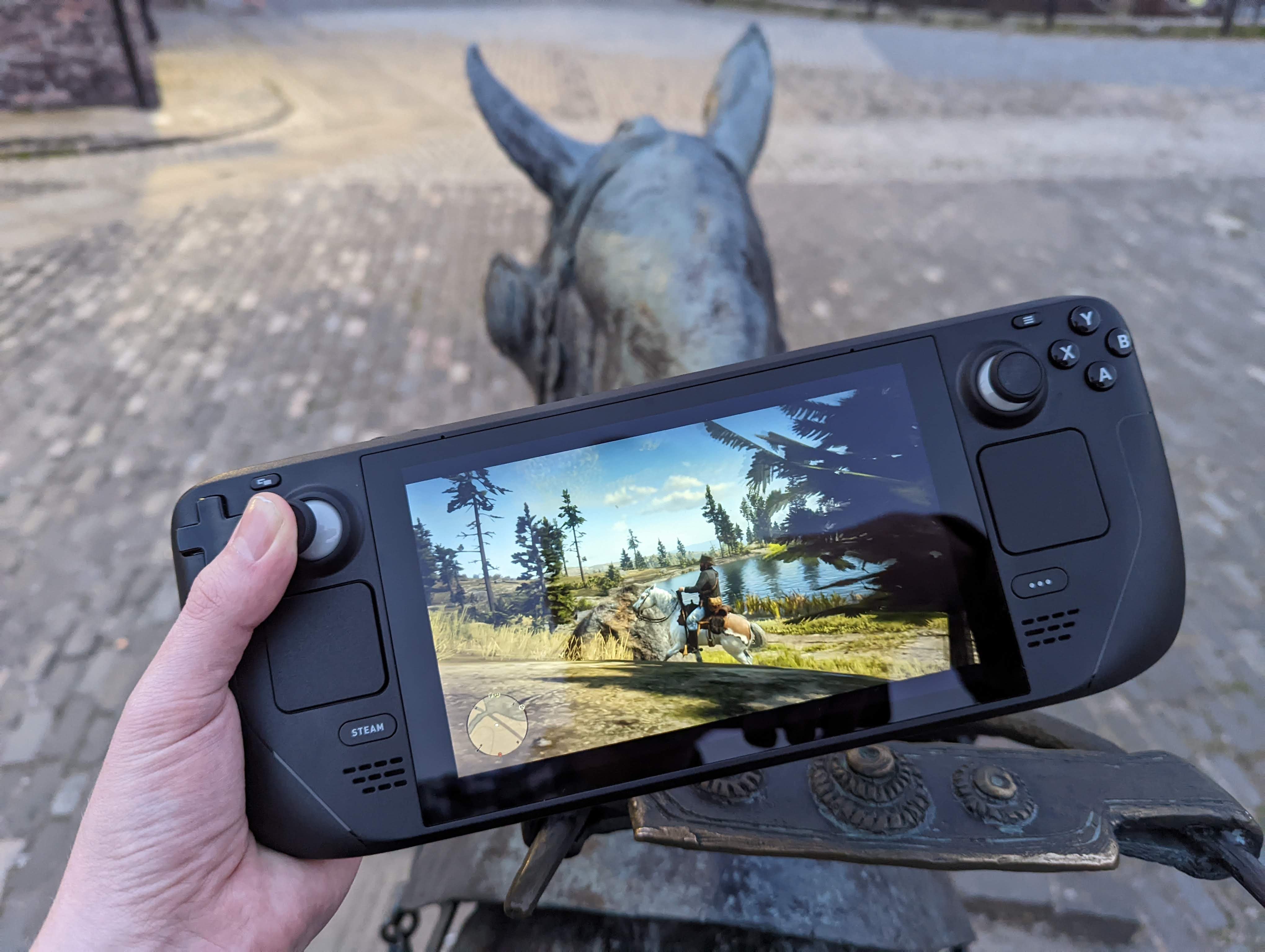 The fuller image of playing Red Dead Redemption 2 on a Steam Deck, while on the back of a horse statue.  You love to see it.
