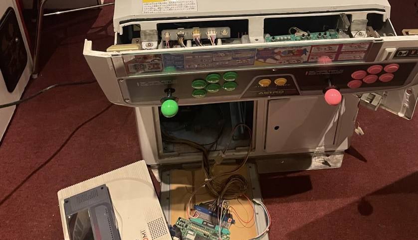 An arcade cabinet not quiet put together. The front panel is hanging off, with the joysticks and buttons on, and its belly is exposed and wires - like entrails - are spilling out. I might have made that sound more graphic than it actually is.