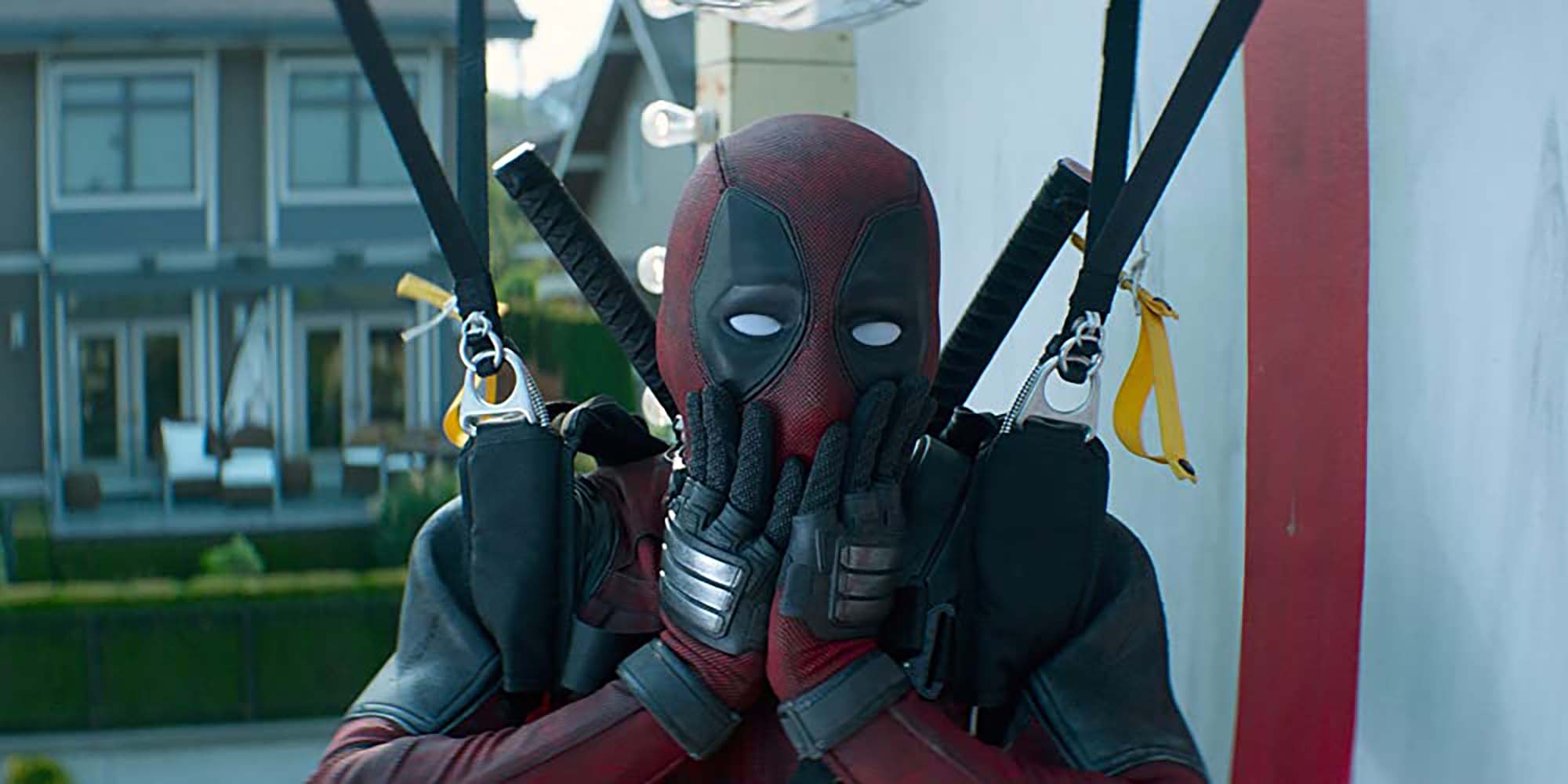 A man in a Deadpool costume with his hands on his face in mock surprise. Deadpool 2 still