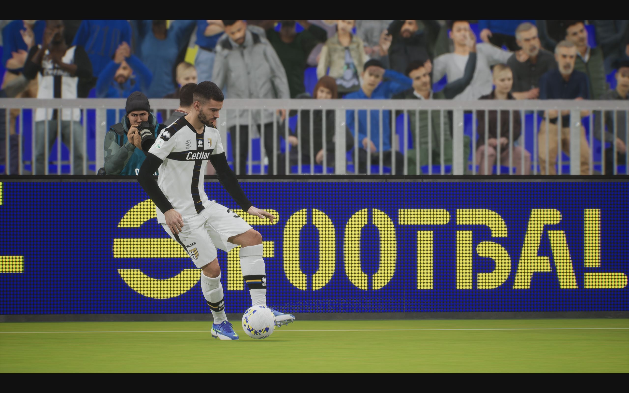 eFootball review: A player in Parma's black and white home kit passes the ball from a cinematic, sideways angle.