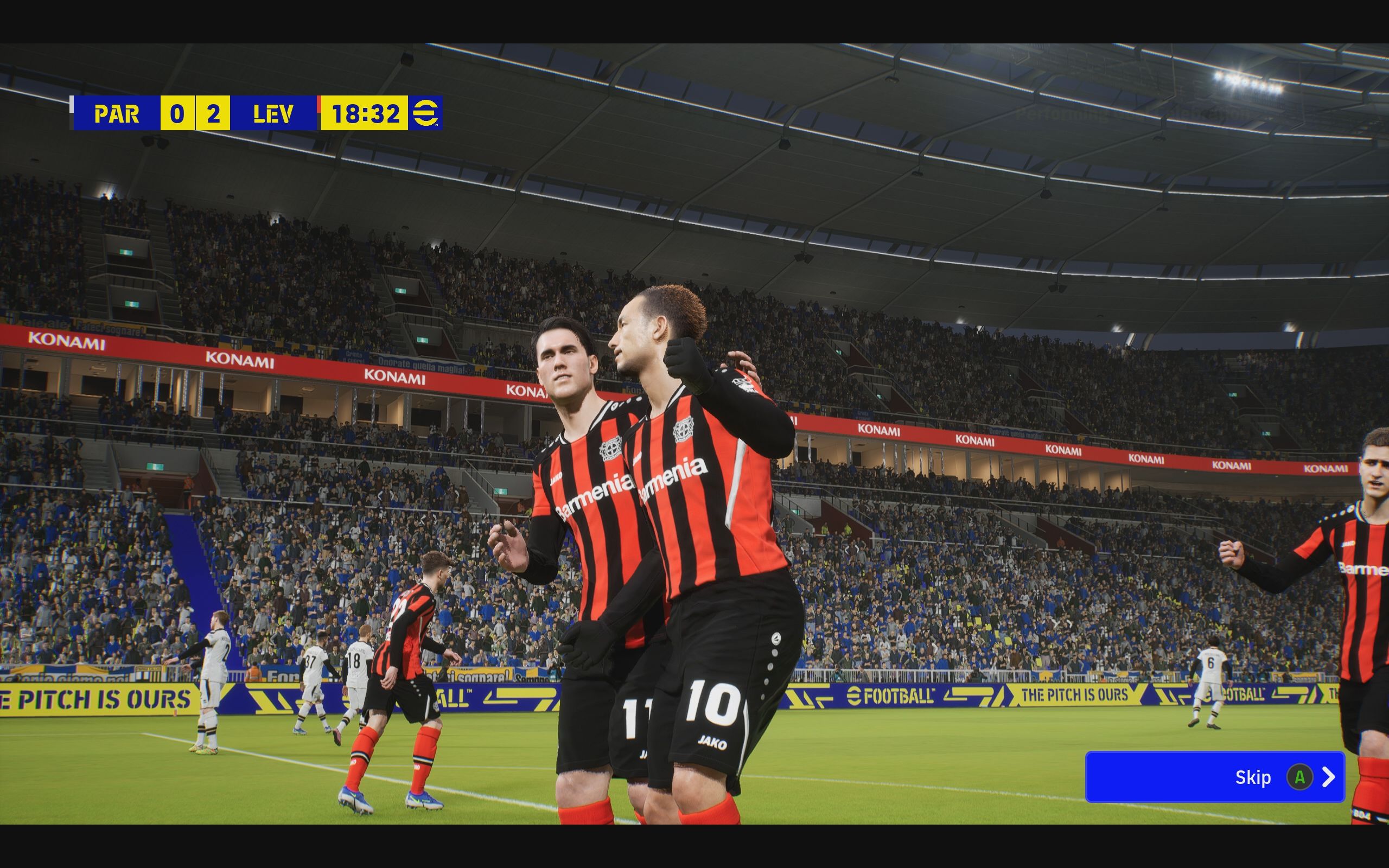 eFootball review: Two players in red and black vertical striped kits celebrate a goal.