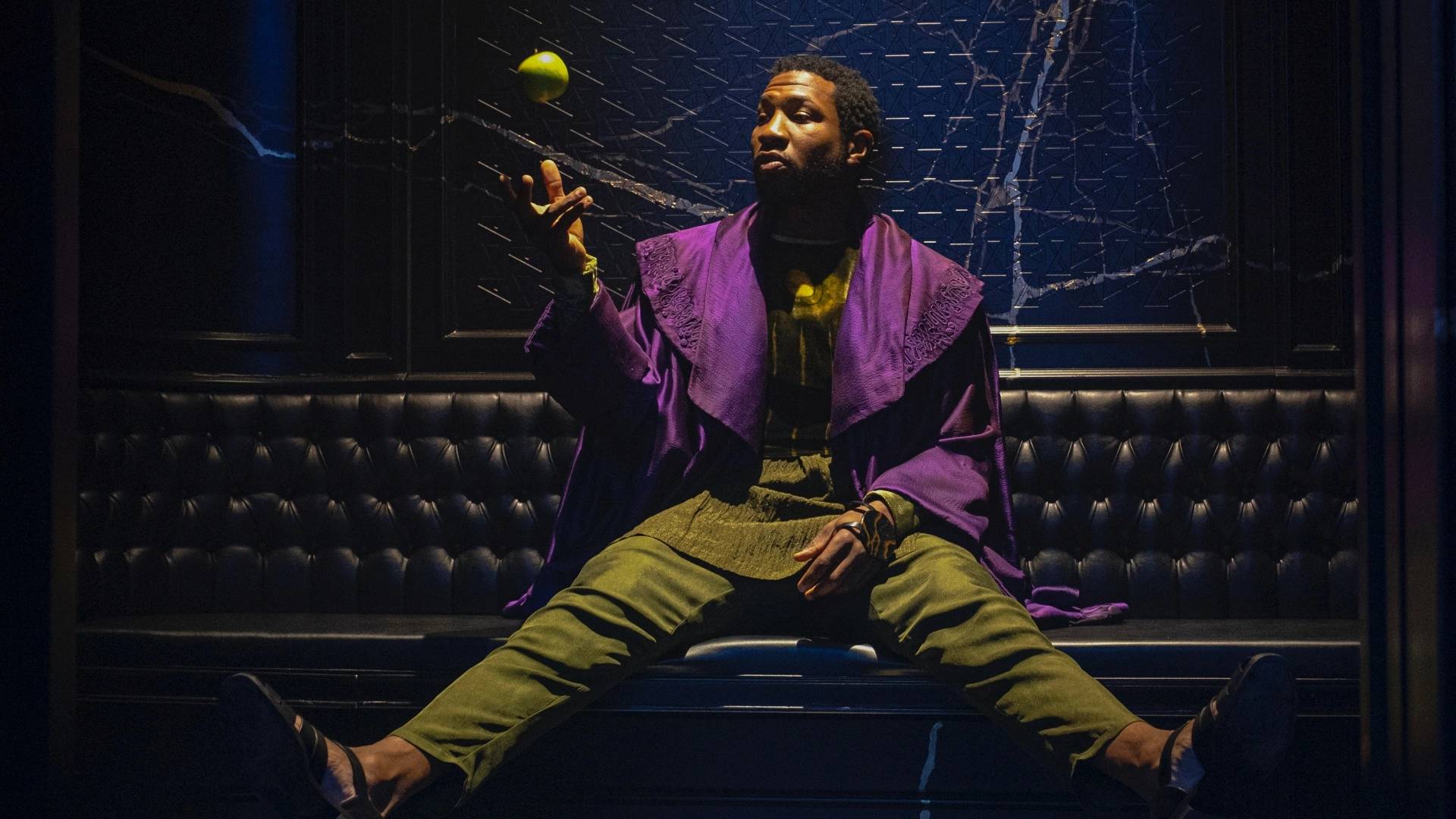 Jonathan Majors as He Who Remains tossing an apple into the air