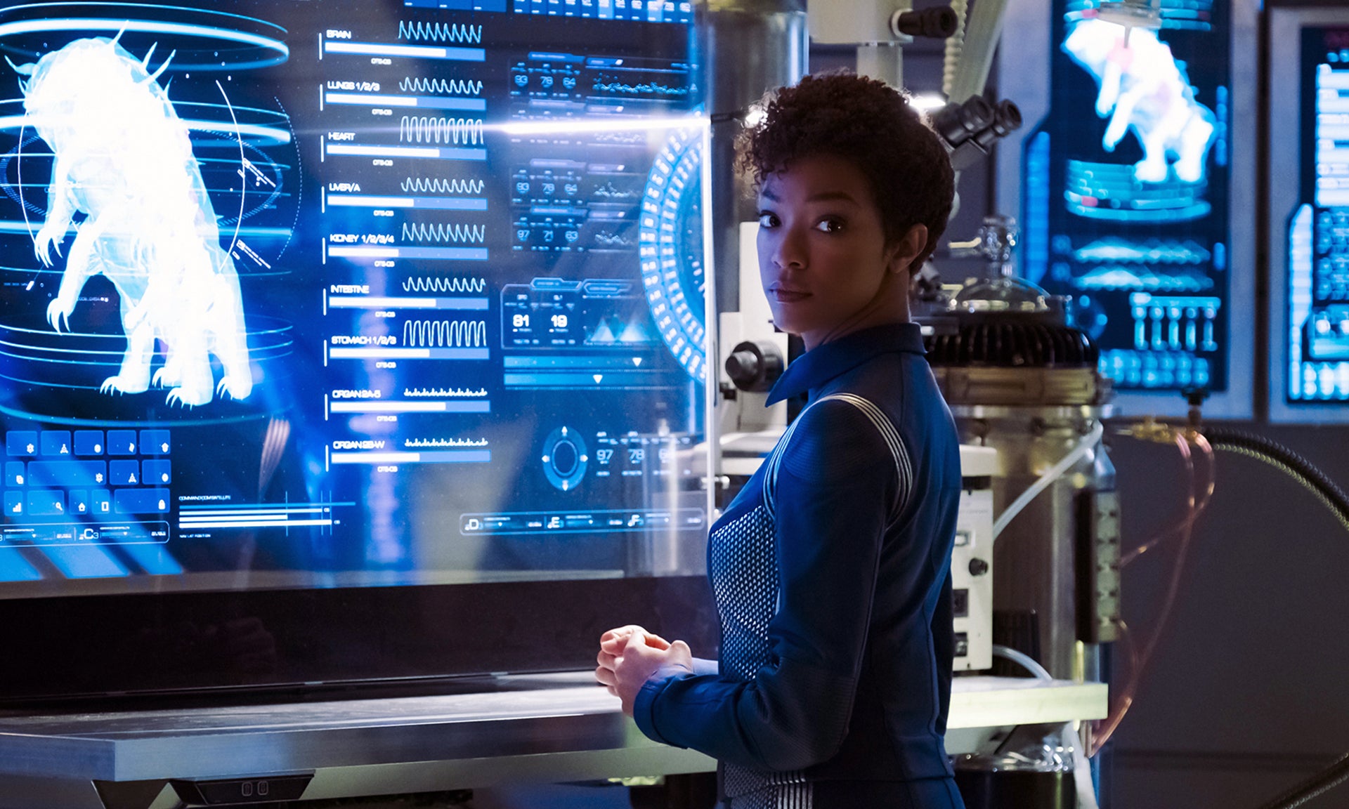Still image of Michael Burnham in Star Trek Discovery standing in front of screens