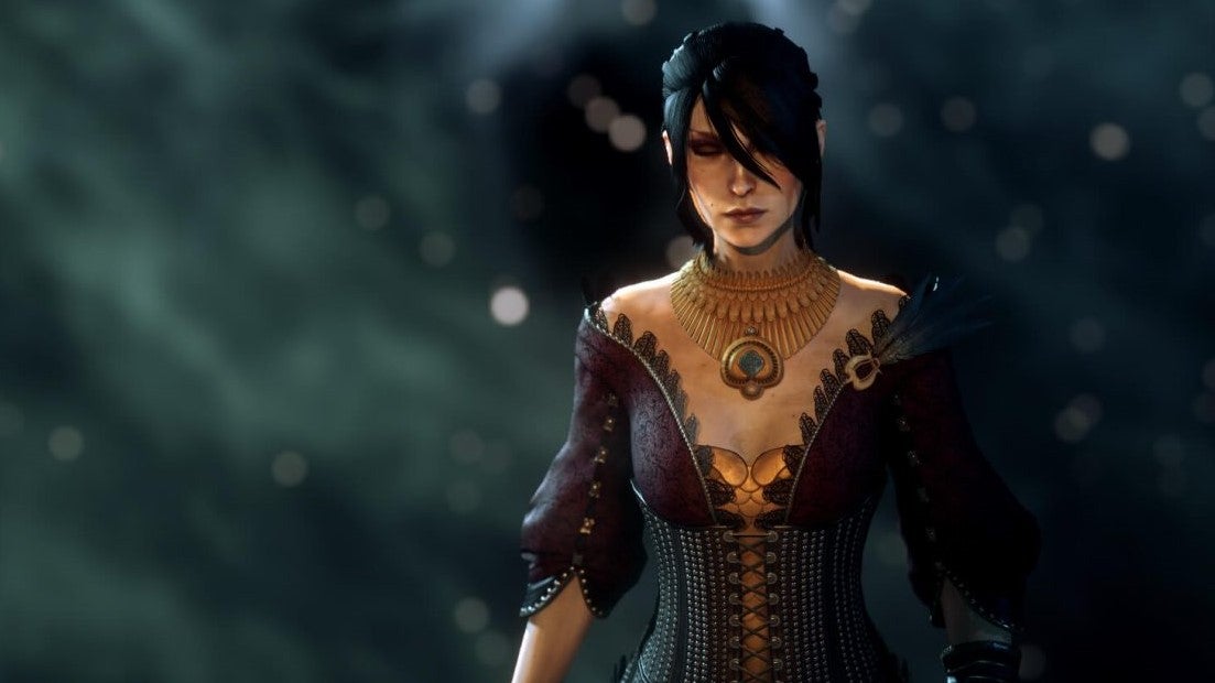A raven-haired woman in period costume closes her eyes as some kind of magical force swirls around her. It's Morrigan from Dragon Age.