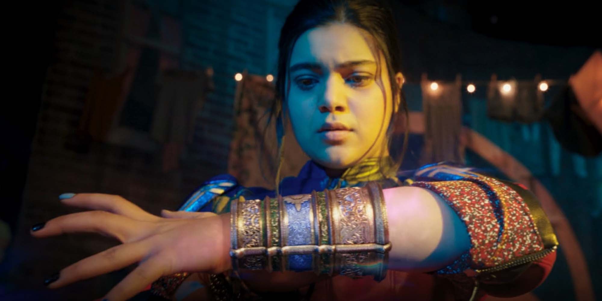 Ms marvel bangles: In a screencap from the Disney+ show Ms. Marvel, Kamala Khan, played by Iman Vellani, looks at the jewelry on her wrist as she realizes they are superpowered.