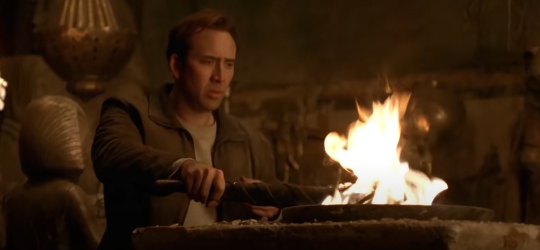 Still image of Nick Cage holding a torch to a flame