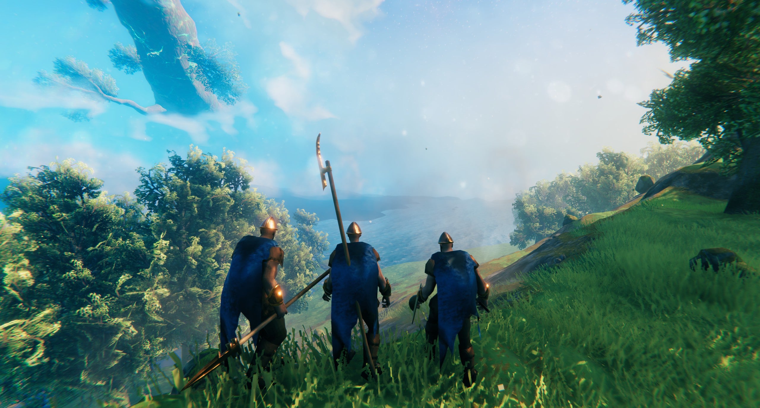 state of the game valheim - exploring as a trio looking out over grassy hills under a blue sky