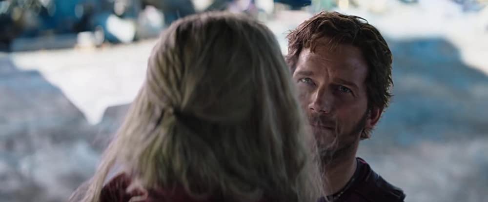 Still from 'Thor: Love and Thunder' The back of Thor's blonde head and he is facing a smug looking Chris Pratt as Star Lord